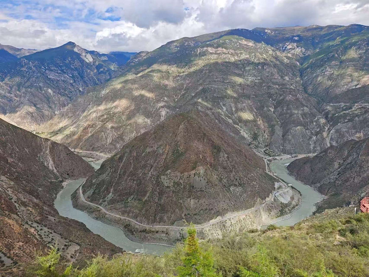 Here, the Jinsha River, after traveling roughly southeast down off the Tibetan Plateau for 1000+ km, rounds a huge bend in the topography and seemingly suddenly heads off due east. In reality, it resumes its southerly direction shortly thereafter, but you can’t see it from this viewing location. David Fishman